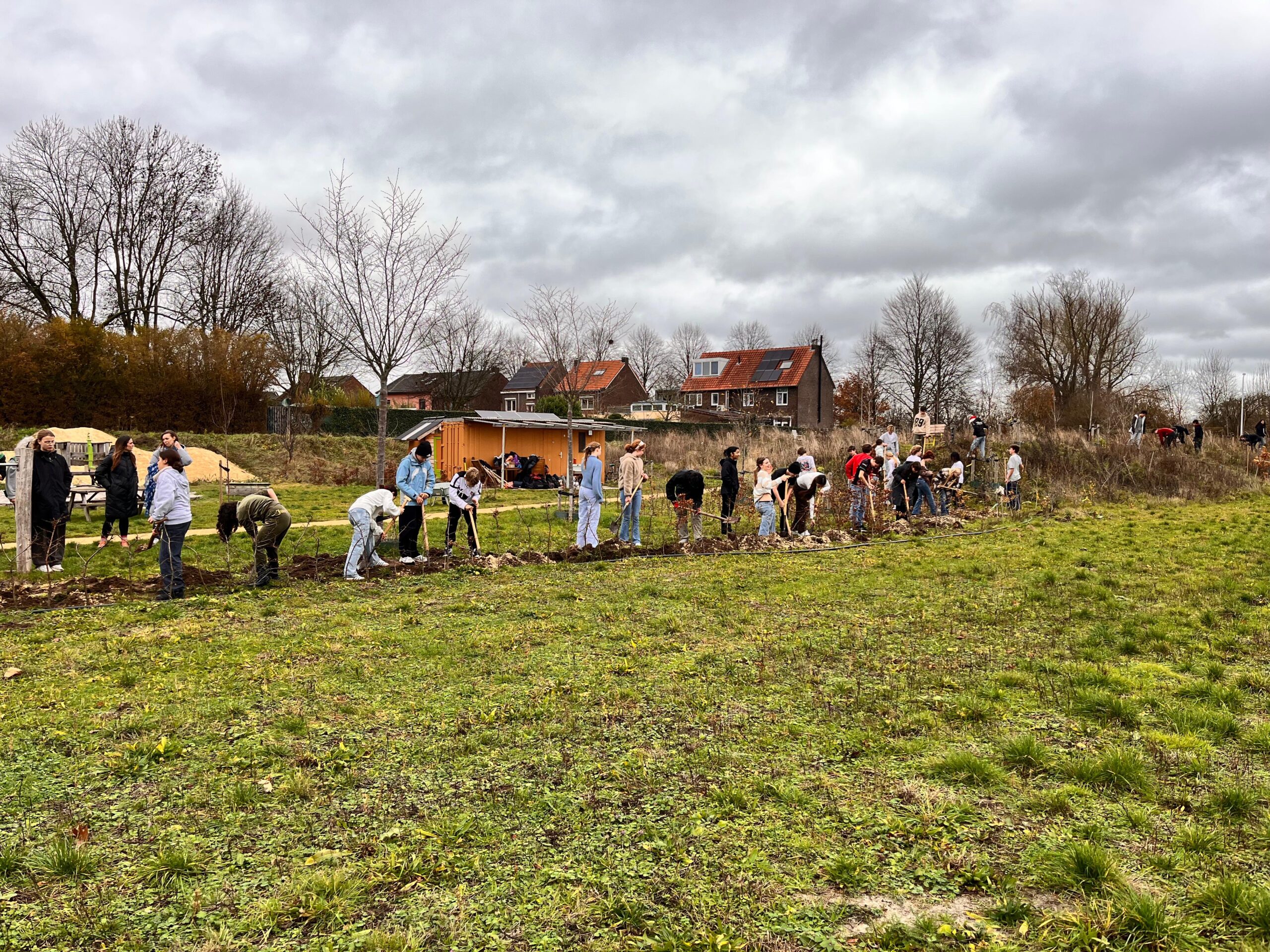 Ruim 20 leerlingen van het UWC graven een geul.